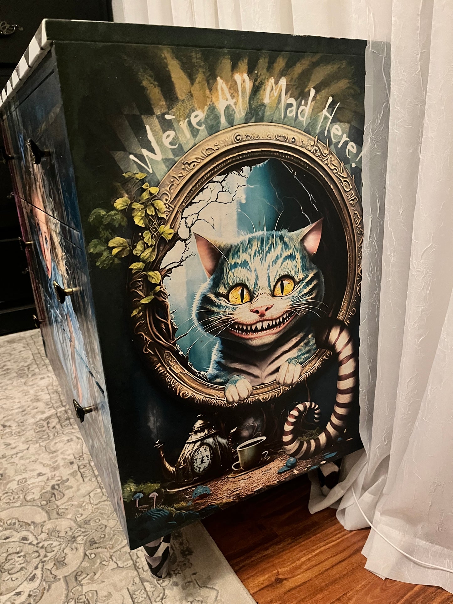 Decorative box with a Curios Cheshire Cat  on top of a wooden surface