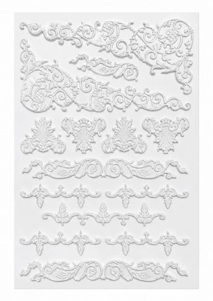 White embossed decorative scroll and floral border designs arranged in rows on a white background.