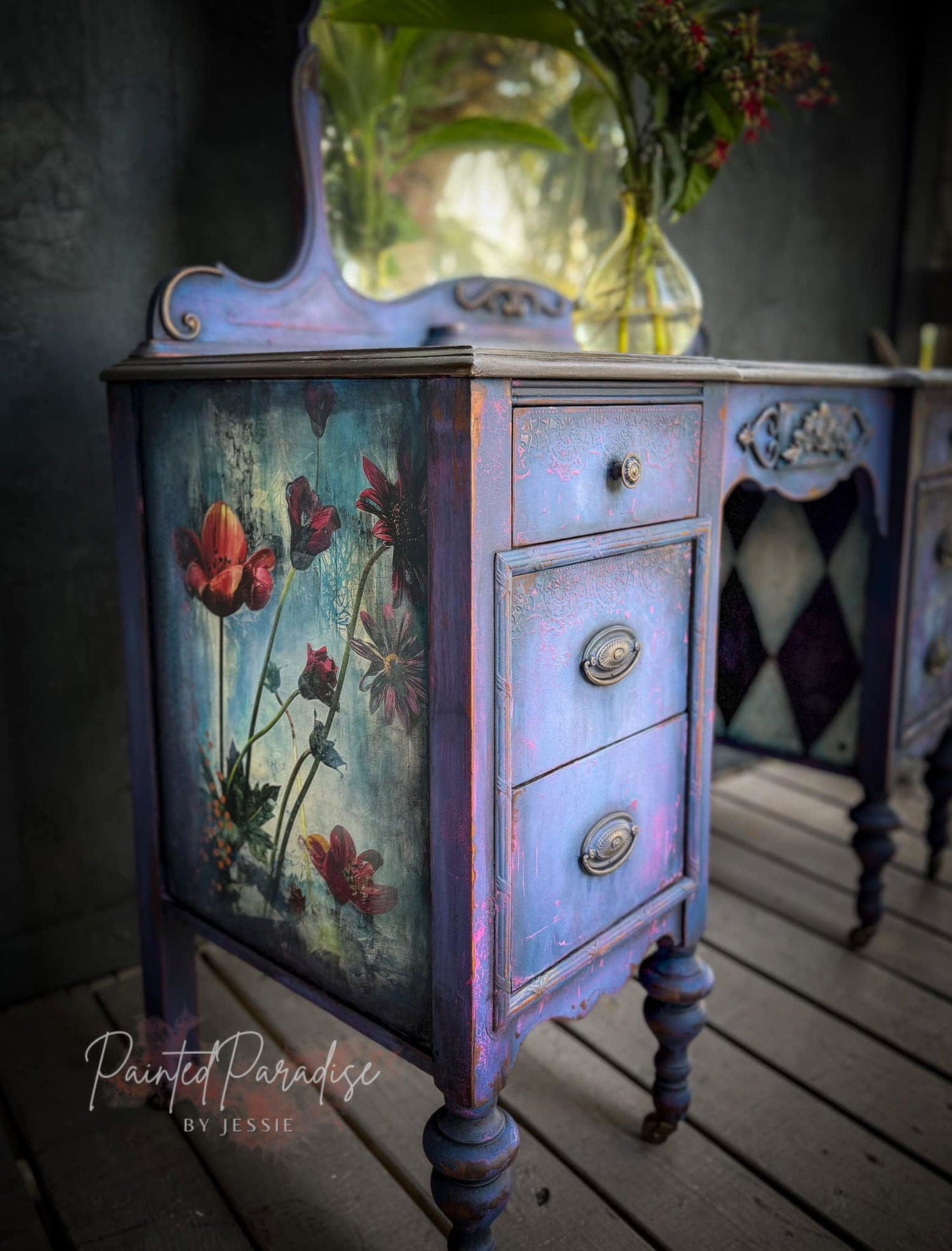 Decorative wooden cabinet with floral design on a wooden floor.